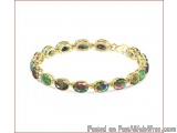 The image is of a gold bracelet with a chain link design. The bracelet is made up of small, oval-shaped gemstones in various...