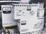 The image shows three white cardboard boxes stacked on top of each other on a wooden pallet. The boxes are labeled "Jandy" an...