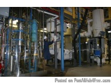The image shows a large industrial space with multiple pipes, valves, and equipment. The space appears to be a factory or a m...