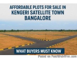 The image shows an empty road in Kengeri Satellite Town, Bangalore, India. The road is surrounded by dry land and there are n...