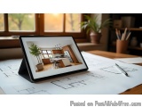 The image shows a tablet on a desk with architectural drawings and a pen. The tablet is placed on top of a blueprint or archi...