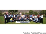 The image shows a group of people posing for a group photo on a grassy field. There are around 20 people in the photo, all of...