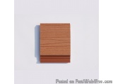 The image is a photograph of a square-shaped wooden block. The block appears to be made of a light-colored wood with a smooth...
