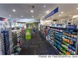 The image shows the interior of a supermarket aisle. The aisle is filled with various items for sale, including snacks, drink...