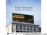 The image shows a large billboard on the side of a building. The billboard is green and yellow in color and has the words "Dr...