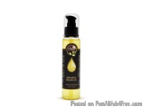 The image is of a bottle of organic argan oil. The bottle is tall and slender with a black spray nozzle on top. The label on...