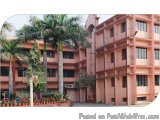 The image shows a large pink-colored building with multiple floors and balconies. The building appears to be a residential co...