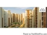 The image shows a group of high-rise apartment buildings with a park in the foreground. The buildings are made of concrete an...
