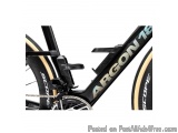 The image is a close-up of the front part of a black and gold-colored bicycle. The frame of the bike is black with the word "...