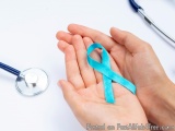 The image shows a pair of hands holding a blue ribbon. The ribbon is tied in a neat knot and appears to be made of a shiny ma...