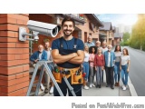 The image shows a group of people standing on a street in front of a brick building. In the center of the image, there is a m...