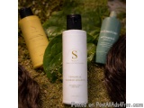 The image shows three hair care products from the brand Fenugreek Shuddhi Shampoo. The products are placed on a bed of green...