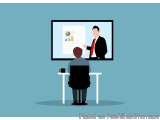 The image shows a man sitting at a desk in front of a large screen with a presentation on it. The presentation is titled "Bus...