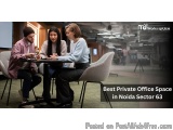 The image shows three young people sitting around a table in a modern office space. They are engaged in a conversation and ap...