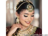 The image is a close-up portrait of a beautiful Indian woman wearing traditional Indian jewelry. She is wearing a maroon and...