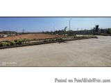The image shows an empty parking lot with a clear blue sky in the background. The parking lot appears to be empty, with no pe...