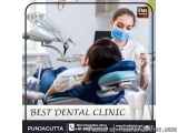 The image shows a dental clinic in Punjab, India. There is a young woman sitting in a dental chair with her mouth open, while...
