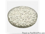 The image shows a round glass plate filled with small, round, white balls. The balls appear to be made of plastic or a simila...