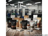 The image shows a collection of coffee bags arranged on a wooden table in a coffee shop. There are nine bags in total, each w...