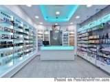 The image shows the interior of a beauty store. The store has a modern and spacious design with a white counter in the center...