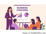 The image shows a business coaching session taking place in a conference room. There is a woman standing in front of a whiteb...