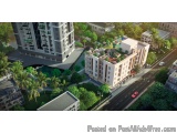 The image is an aerial view of a modern residential complex. The complex is surrounded by lush greenery and palm trees. There...