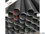 The image shows a group of black steel pipes stacked on top of each other. The pipes appear to be made of a shiny, metallic m...