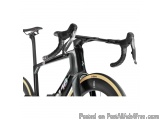 The image is a close-up of the handlebars of a black and white road bike. The bike has a sleek and modern design with a black...