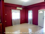 The image shows an empty room with red walls and white flooring. The walls are painted in a deep red color and there is an ai...