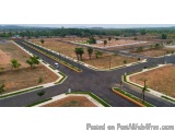 The image shows an aerial view of a residential area. The area is surrounded by trees and shrubs, and there are several roads...