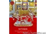The image is a photograph of a gold and silver plated Kamadhenu idol, which is a traditional Indian decoration. The idol is i...