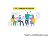The image shows a group of people sitting around a table in a meeting room. There are four people in the image, three men and...