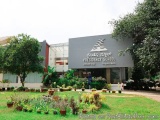 The image shows the entrance of a school named Presidency School. The school is located in a residential area with a large bu...