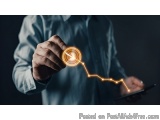 The image shows a person's hand holding a tablet with a line graph on it. The line graph is glowing orange and appears to be...