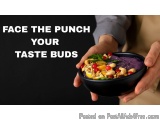 The image shows a pair of hands holding a black bowl filled with a colorful salad. The salad appears to be made up of various...