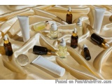 The image shows a collection of small glass bottles and tubes arranged on a golden satin fabric. The bottles are of different...