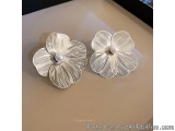 The image shows a pair of earrings in the shape of flowers. The earrings are made of silver and have a delicate, intricate de...