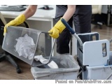 The image shows a person's hands wearing yellow rubber gloves and using a mop to clean a trash can. The person is holding the...
