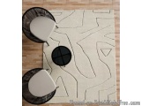 The image shows a modern living room with a white area rug on the floor. The rug has a geometric design with black lines and...