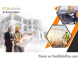 The image is an advertisement for PC Bodiwala & Associates, a construction company. It features three men wearing hard hats a...