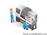 The image shows two workers in blue overalls and yellow hard hats working on a large industrial machine. The machine appears...