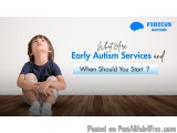 The image shows a young boy sitting on the floor with his legs crossed and his hands clasped together in front of him. He is...