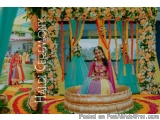 The image shows a beautiful Indian wedding ceremony taking place in a traditional Indian venue. The focal point of the image...
