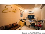 The image shows a modern home recording studio with a desk and a sofa. The desk has a computer monitor, keyboard, and speaker...