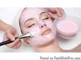 The image shows a young woman lying down with her eyes closed, receiving a facial treatment. She is wearing a white headband...