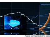 The image shows a computer monitor with the word "salesforce" written on the screen in blue. The monitor is placed on a black...