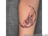 The image is a tattoo on someone's arm. It is a black and white illustration of two hands holding each other, with the finger...