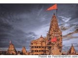 The image is a photograph of a Hindu temple in India. The temple is made of stone and has intricate carvings and designs on i...