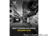 The image is a black and white photograph of a street in a city. The street is lined with tall buildings on both sides and th...