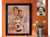 The image is a framed photograph of a couple and their dog. The photograph is in a black frame and is hanging on an orange wa...